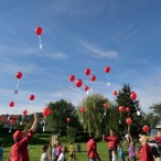 Kinder und Betreuer beim Steigenlassen der Luftballons.