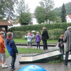 Mehrere Gruppen Kinder beim Minigolfspielen