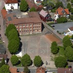 Die Grundschule von oben. Die Anbauten sollen hinter dem Gebäude entstehen. Das weiße Haus hinten soll abgerissen werden. Für Eltern, die ihre Kinder mit dem Auto bringen, sollen neue Haltepätze in dem Bereich rechts unten entstehen.  --  Foto: Bleß