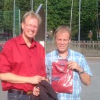 Dr. Gans (links) überreicht das rote Hemd an Thomas Memke
