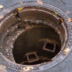 Hier hat sich die Fahrbahn über dem Kanalschacht seitlich verschoben. Der Deckel befindet ich nicht zentriert über dem Schacht.