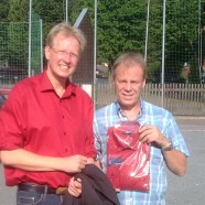 Dr. Gans (links) überreicht das rote Hemd an Thomas Memke